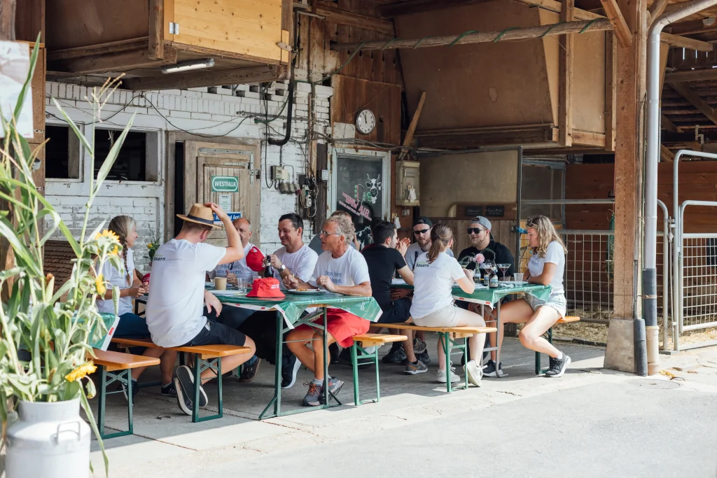 Gli ospiti sono seduti sulle panche da festa davanti al fienile.