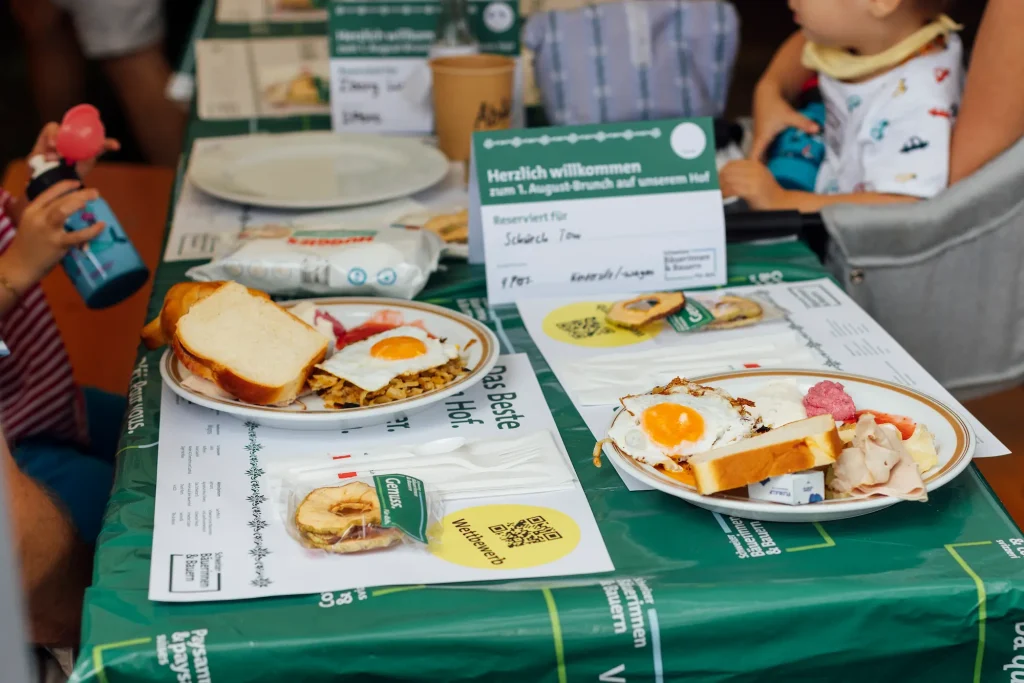 Tavola apparecchiata con piatto da colazione, uovo e pane su una tovaglia verde.