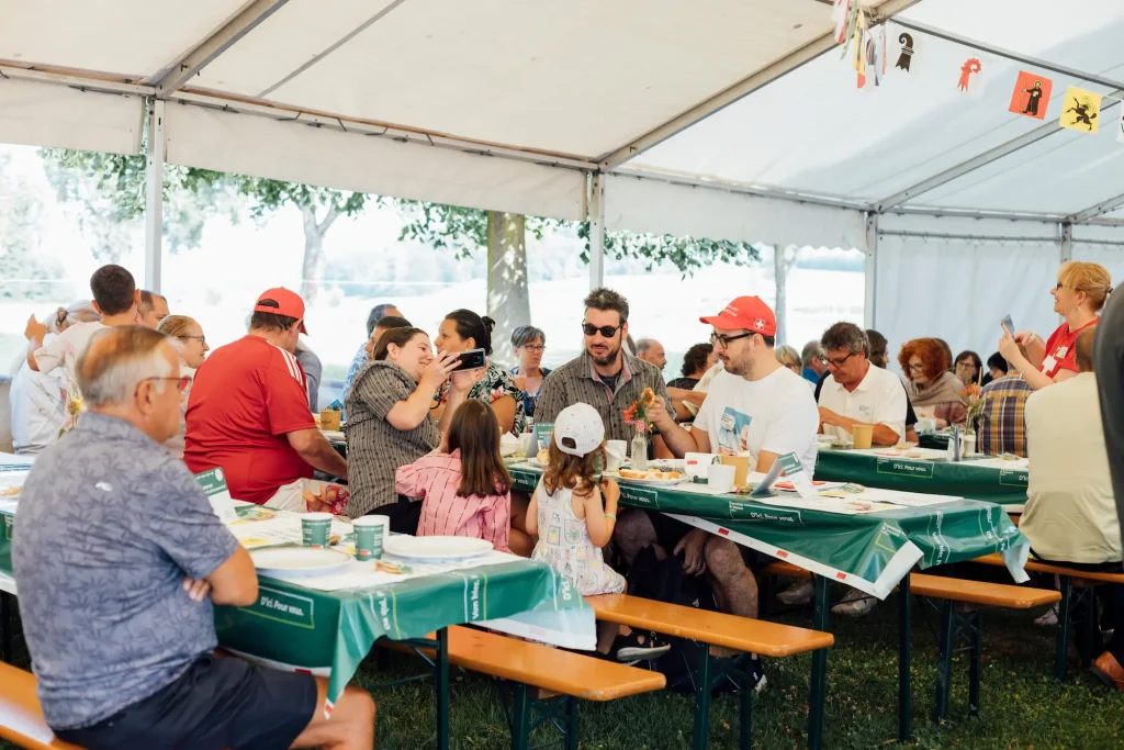 Gli ospiti sono seduti sulle panche da festa sotto un tendone e si godono il brunch.